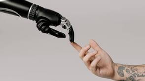 Mensch und Maschine arbeiten zusammen Roboterhand und Menschenhand berühren sich
