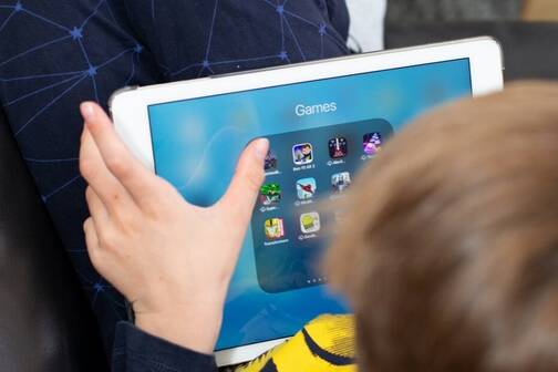 iPad als Spielgerät einsetzen Ein Junge verwendet sein iPad fürs mobile Gaming