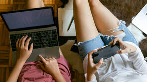 Zwei Personen mit MacBook und iPhone