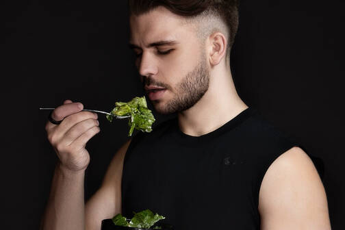 Mit dem Ultrahuman Ring Air Stoffwechsel überwachen Mann mit Ultrahuman Ring Air am Finger isst Salat