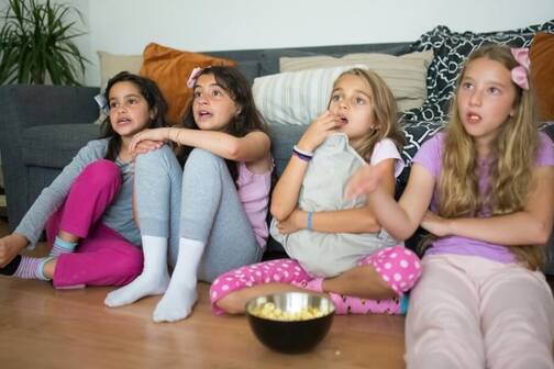Disney+ bietet Unterhalten für Kinder und Erwachsene (Foto: Kampus / pexels) vier Mädchen sitzen mit Popcorn vor Bildschirm
