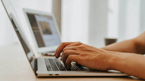 Zwei Männerhände auf Tastatur von MacBook