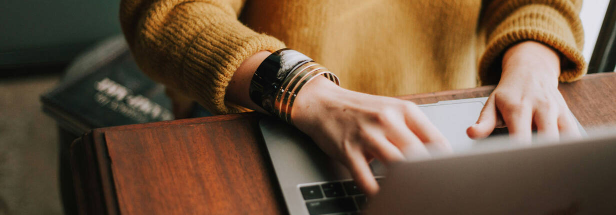 Frau beim MacBook einrichten (Foto: Christin Hume / unsplash) Neues MacBook konfigurieren